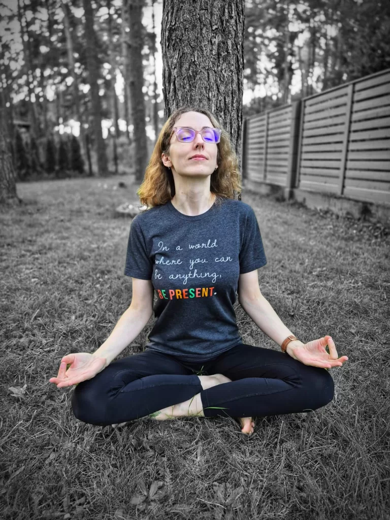 woman meditating in mantra staples shirt that says be present